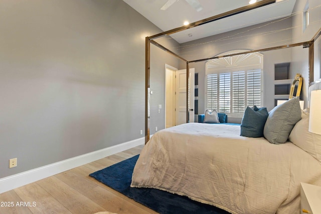 bedroom featuring a ceiling fan, baseboards, and wood finished floors