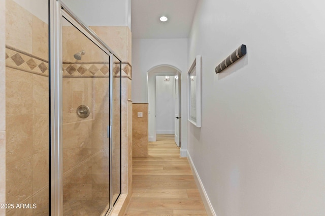 interior space with a stall shower, wood finished floors, and baseboards