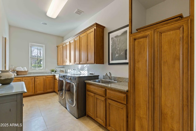 washroom with light tile patterned floors, cabinet space, visible vents, a sink, and independent washer and dryer