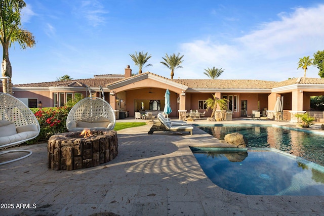 outdoor pool featuring an outdoor living space with a fire pit and a patio