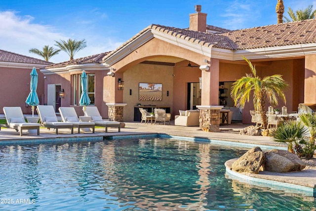 pool with a ceiling fan and a patio