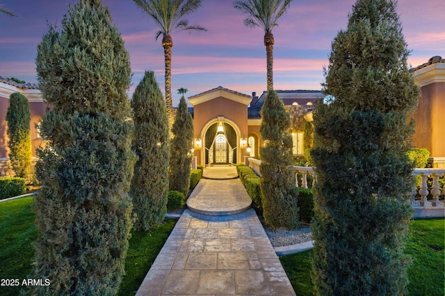 view of front of property featuring a tiled roof and stucco siding