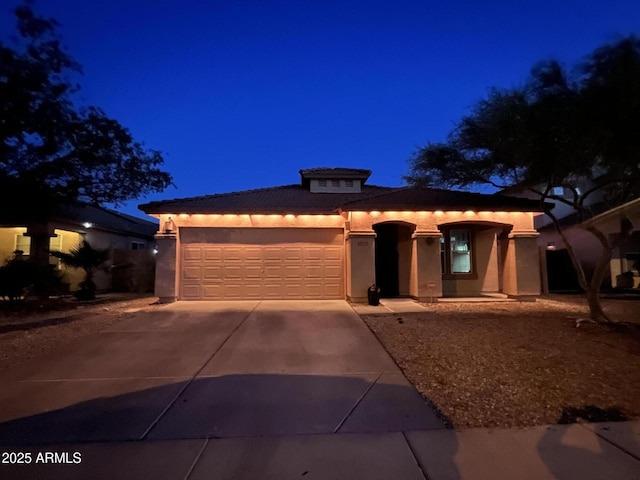 24229 W Tonto St, Buckeye, AZ 85326 - mediterranean / spanish home with concrete driveway, an attached garage, stucco siding, and a tiled roof