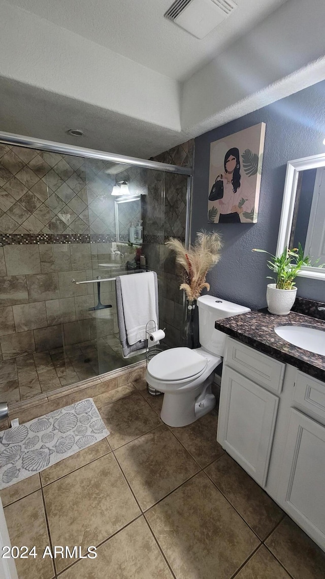 bathroom with walk in shower, tile patterned floors, toilet, and vanity