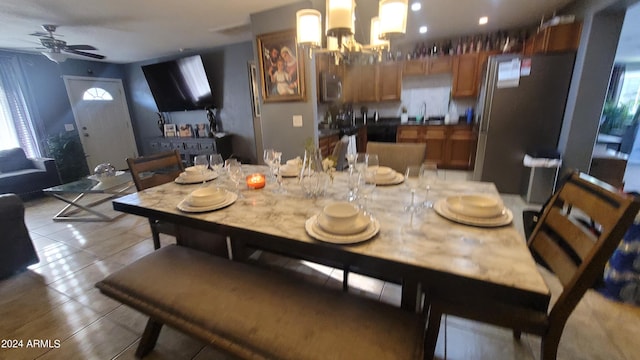 dining room with sink, ceiling fan with notable chandelier, and light tile patterned floors