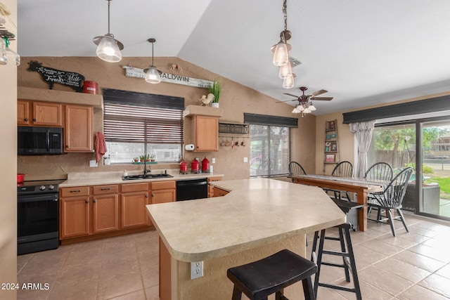 kitchen with pendant lighting, lofted ceiling, sink, a breakfast bar area, and black appliances