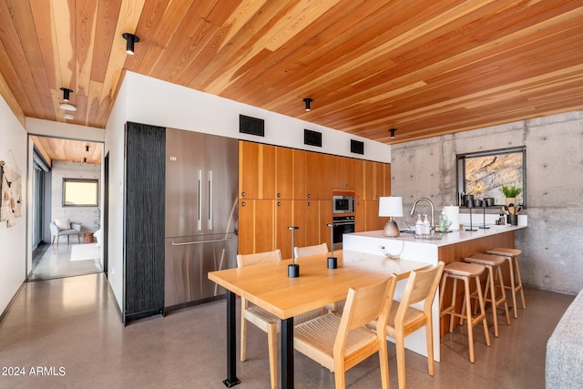 dining space with wood ceiling and sink