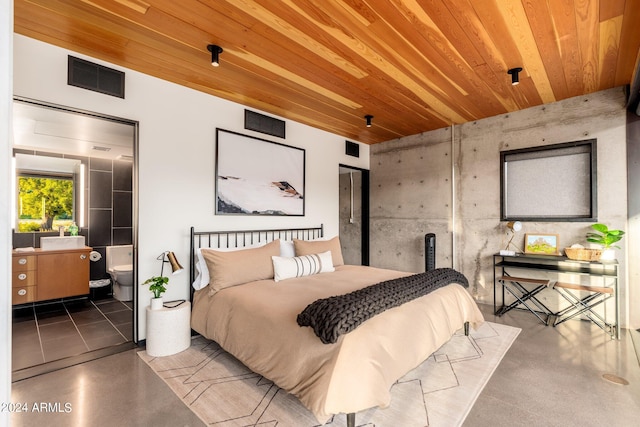 bedroom with connected bathroom, concrete flooring, and wooden ceiling