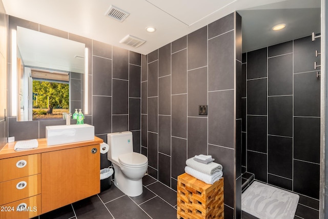 bathroom with vanity, toilet, and tile walls