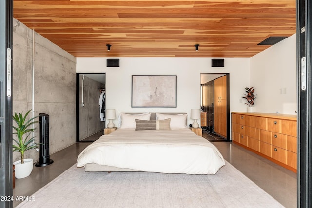 bedroom with a closet, concrete floors, and wooden ceiling