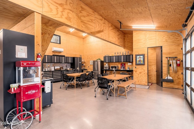 dining area featuring a high ceiling, a wall mounted AC, and concrete floors