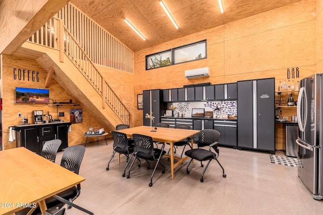 dining space with a towering ceiling and a wall unit AC