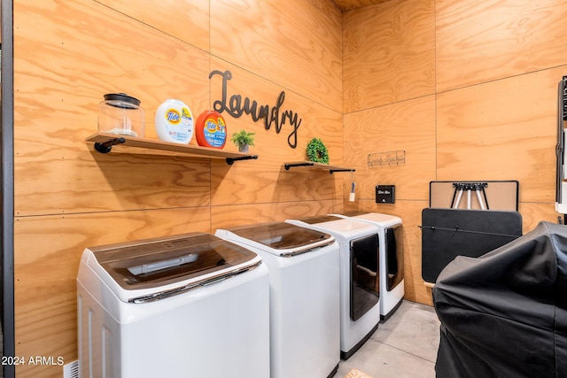 laundry area with washer and clothes dryer and wooden walls