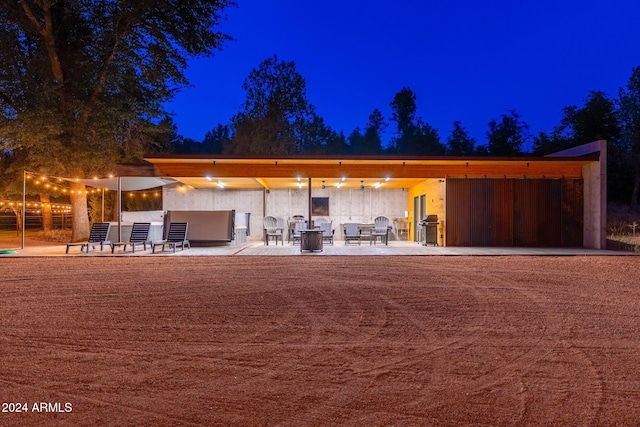 back house at twilight with a patio area