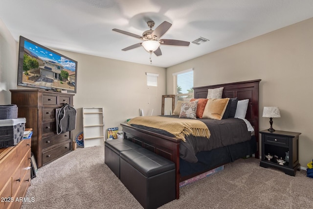 carpeted bedroom with visible vents and ceiling fan