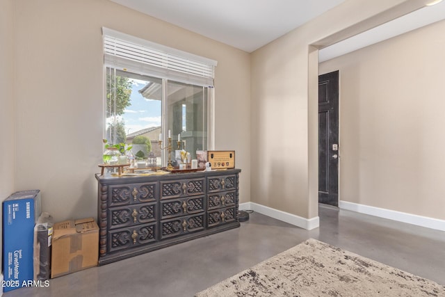 interior space with finished concrete flooring and baseboards