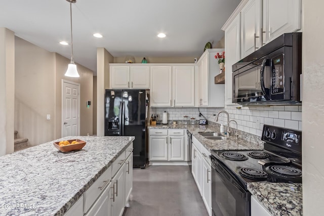 kitchen with finished concrete flooring, white cabinets, tasteful backsplash, a sink, and black appliances