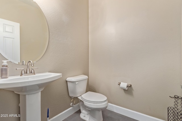 bathroom with baseboards and toilet
