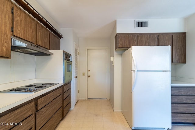 kitchen featuring oven, electric stovetop, and white refrigerator