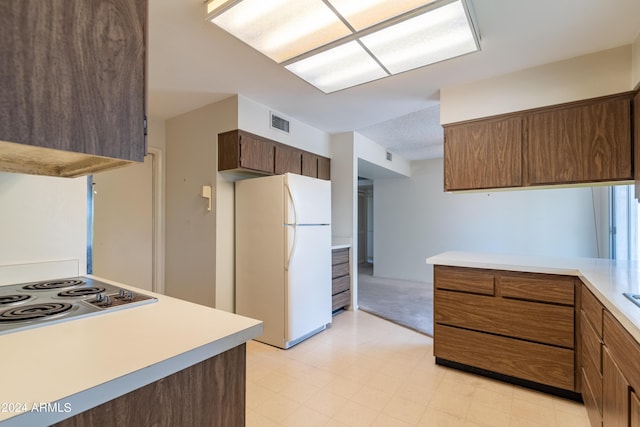 kitchen with cooktop and white fridge