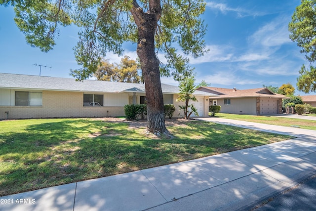 ranch-style house with a garage and a front lawn