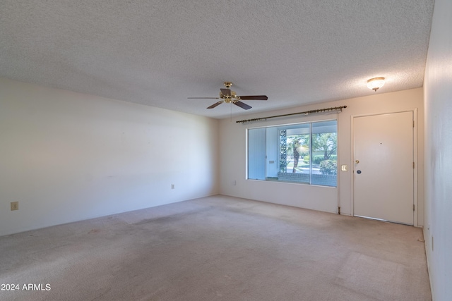 carpeted spare room featuring a textured ceiling and ceiling fan