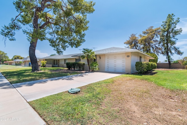 single story home featuring a garage and a front lawn