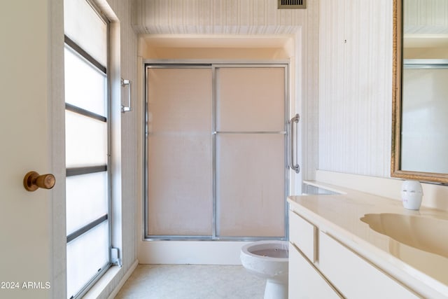 bathroom featuring an enclosed shower, vanity, and toilet