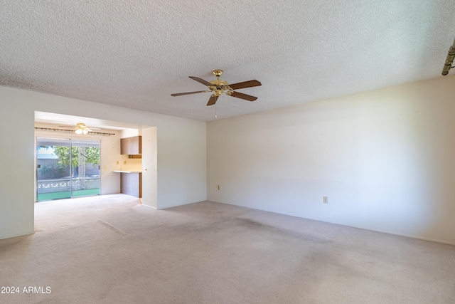 unfurnished living room with light carpet, a textured ceiling, and ceiling fan