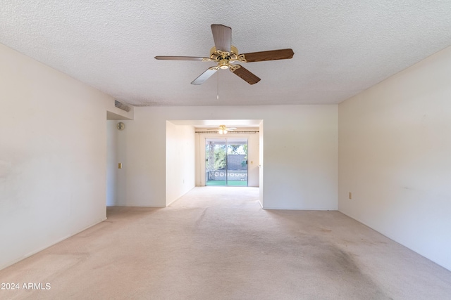 unfurnished room with light carpet and a textured ceiling