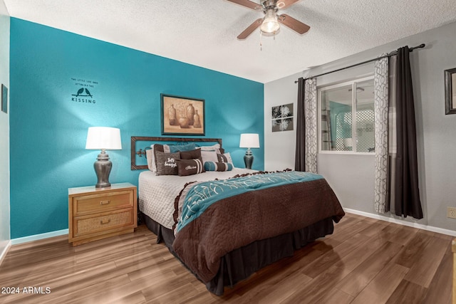 bedroom featuring hardwood / wood-style floors, a textured ceiling, and ceiling fan