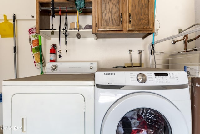 laundry room with cabinets and washer and clothes dryer