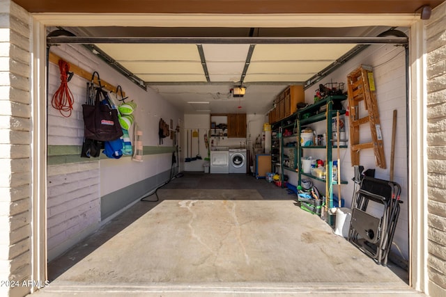 garage with a garage door opener and washer and dryer