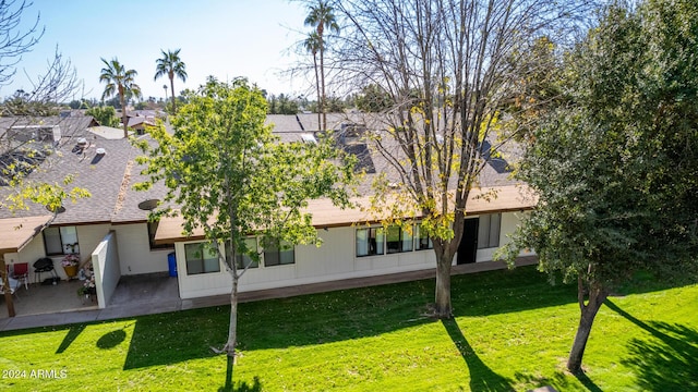 rear view of house with a patio area and a lawn