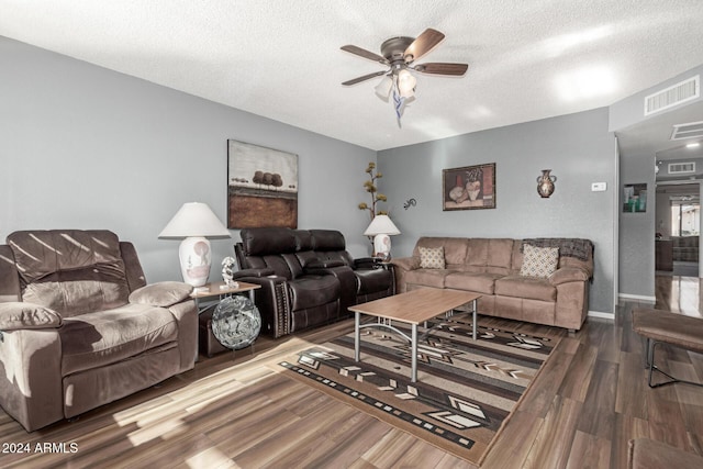 living room with hardwood / wood-style flooring, a textured ceiling, and ceiling fan