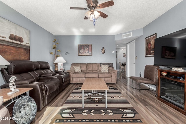 living room with ceiling fan, hardwood / wood-style floors, and a textured ceiling