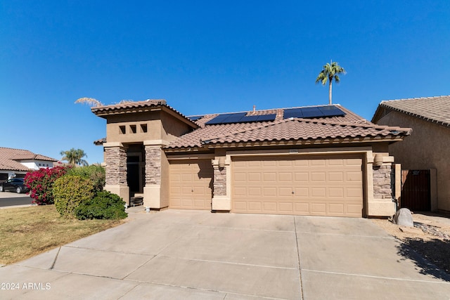 view of front of property with solar panels and a garage