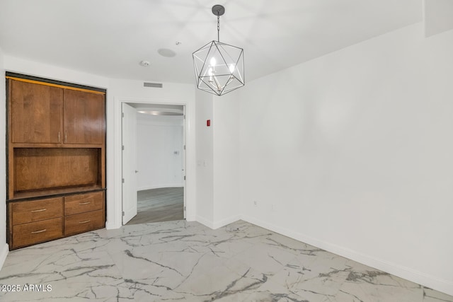 unfurnished dining area featuring a chandelier