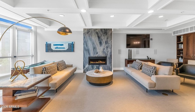 living room with coffered ceiling, a premium fireplace, and beamed ceiling