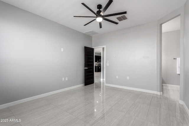 unfurnished room with baseboards, visible vents, and ceiling fan