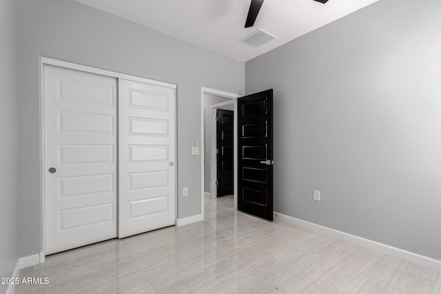 unfurnished bedroom featuring a closet, baseboards, visible vents, and ceiling fan