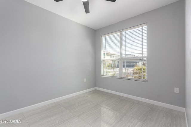 empty room with baseboards and a ceiling fan