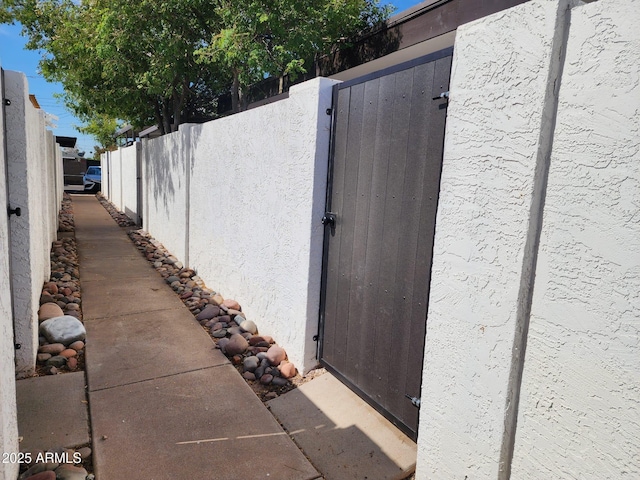 2401 N 70th St Unit G, Scottsdale, AZ 85257 - view of property exterior with stucco siding, fence, and a gate