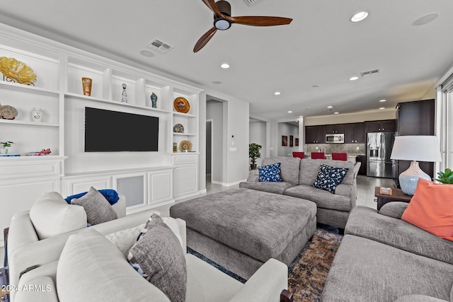 living room with built in features and ceiling fan