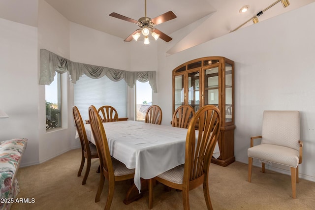 dining area featuring vaulted ceiling, light colored carpet, and ceiling fan