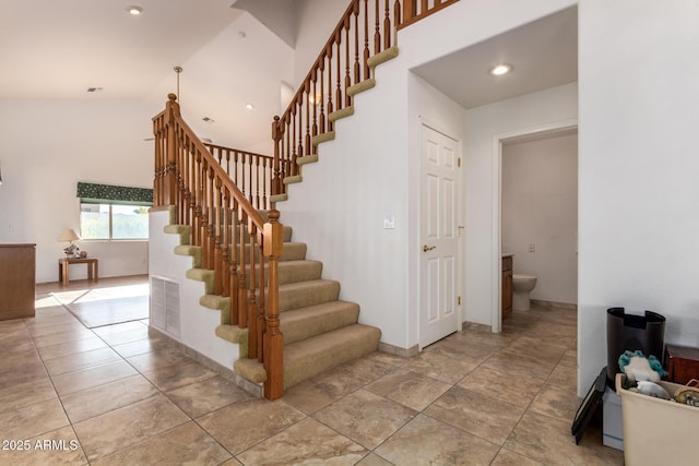 staircase with tile patterned floors and lofted ceiling