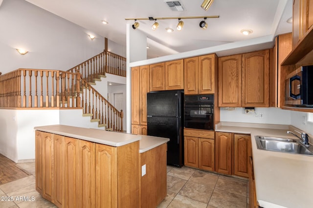 kitchen with light tile patterned flooring, a center island, sink, and black appliances