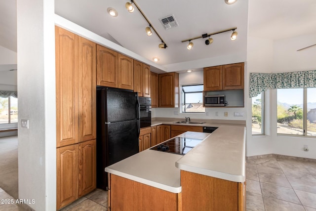 kitchen featuring sink, a wealth of natural light, black appliances, and a center island