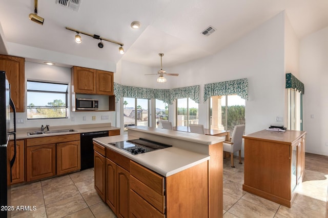 kitchen featuring light tile patterned flooring, a center island, sink, and black appliances