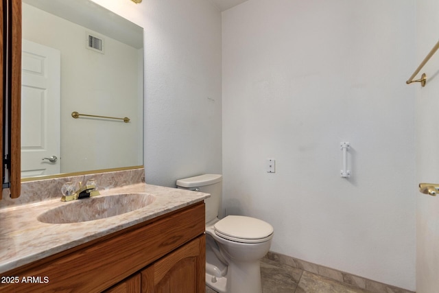 bathroom featuring tile patterned flooring, vanity, and toilet